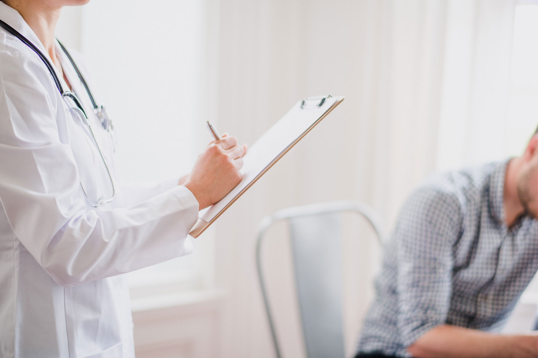 A doctor with a clipboard providing information on services